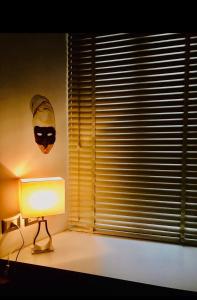 una lampada in una stanza con una maschera sul muro di Arianiello Suite a due passi dal Cristo Velato a Napoli