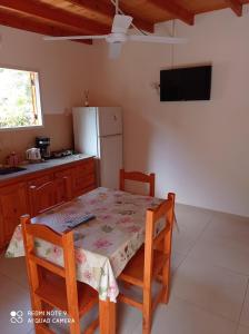 eine Küche mit einem Tisch und Stühlen sowie einem Kühlschrank in der Unterkunft Complejo Valhalla 4 a 300 mts de la PLAYA in Mar Azul