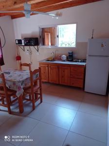 eine Küche mit einem Tisch und einem weißen Kühlschrank in der Unterkunft Complejo Valhalla 4 a 300 mts de la PLAYA in Mar Azul