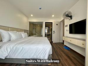 a bedroom with a large white bed with a flat screen tv at Grand Dragon Noi Bai Hotel in Hanoi