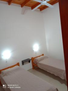 1 Schlafzimmer mit 2 Betten und einem Deckenventilator in der Unterkunft Complejo Valhalla 4 a 300 mts de la PLAYA in Mar Azul