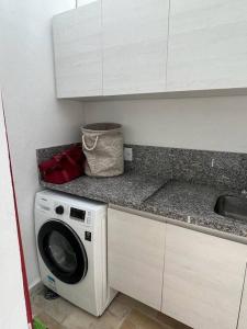 uma cozinha com uma máquina de lavar roupa e um lavatório em Linda casa em Barra do Una em São Sebastião