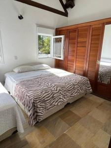 um quarto com uma cama com estampa de zebra num quarto em Linda casa em Barra do Una em São Sebastião