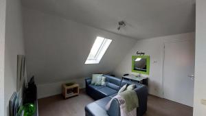 a living room with a blue couch and a window at Honte 2 in Dishoek