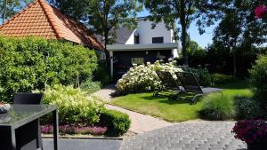 un jardín con un banco frente a una casa en Honte 2 en Dishoek