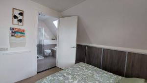 a small bedroom with a bed and a bathroom at Honte 2 in Dishoek