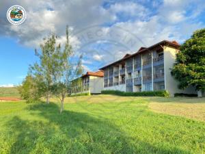 a building with a tree in front of it at Gravatá - Apartamento Família no Monte Castelo in Gravatá