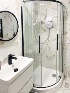 a bathroom with a shower and a white sink at Luxury Stylish studio Flat +spacious Bathroom-no 6 in Leicester