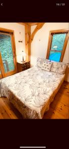uma cama num quarto com duas janelas em Patagonia Home em Shimoda