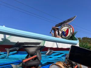 a person taking a picture of a clock on a surfboard at COFFEESWINGS LODGING HOUSE in Vigan