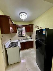 a kitchen with a black refrigerator and brown cabinets at Exclusiva casa de campo con Piscina in Pedro Brand