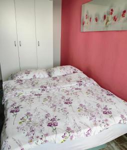 a bed with a floral comforter in a bedroom at Sea Apartment Igalo in Herceg-Novi
