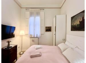 um quarto branco com uma cama e uma janela em casa Guido Reni em Bolonha