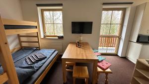 a dorm room with a desk and a bunk bed at Apartmán Kovárna in Prášily