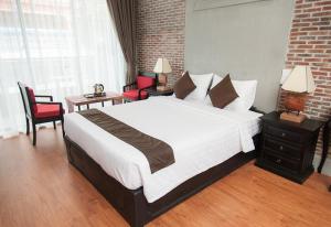 um quarto com uma grande cama branca num quarto em Vacation Boutique Hotel em Phnom Penh