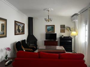 sala de estar con sofá rojo y chimenea en Mirador de Tajos, en Cortes de la Frontera