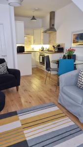 a living room with a couch and a kitchen at Little Sussex House in Rye