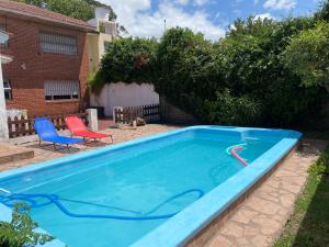 una piscina en un patio con 2 sillas en Santa Cruz 5761 en Mar del Plata