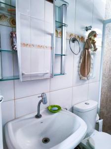 a bathroom with a sink and a mirror and a toilet at Casa 46 in São Sebastião