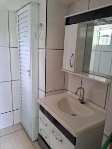 a bathroom with a sink and a mirror at Casa 46 in São Sebastião