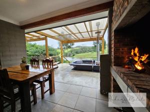 a living room with a fireplace and a table and a tub at Hakuna Matata Game Farm in Great Brak River