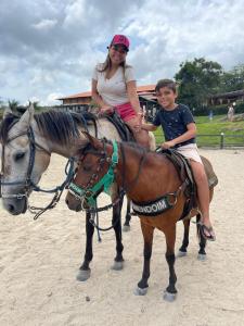 a woman and a child riding on a horse at Gravatá - Apartamento Família no Monte Castelo in Gravatá