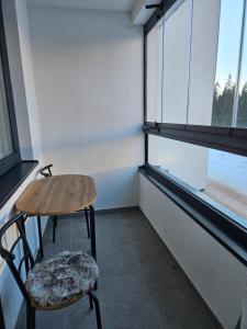 Habitación con 2 sillas, mesa y 2 ventanas en Apartman Novak en Jahorina