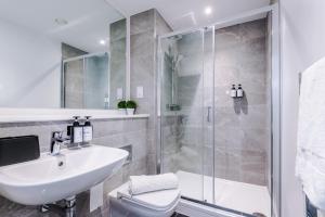 a bathroom with a shower and a sink and a toilet at Waterhouse Suite - Modern 2 Bed in Manchester City Centre- Perfect for Family, Business and Leisure Stays by Dreamluxe in Manchester