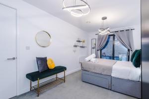 a bedroom with a bed and a mirror and a chair at Waterhouse Suite - Modern 2 Bed in Manchester City Centre- Perfect for Family, Business and Leisure Stays by Dreamluxe in Manchester