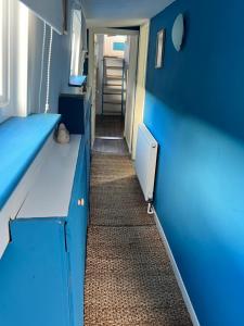 un corridoio di una camera con pareti blu e un corridoio di Judith Barge a Colchester