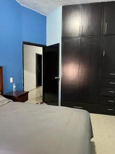 a bedroom with a bed and some black cabinets at Casa de la esquina in Santa María del Oro +6 photos