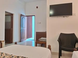 a bedroom with a bed and a television on a wall at Holiday Fashion Inn in Negombo