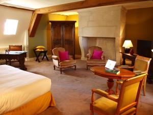 um quarto de hotel com uma cama e uma lareira em La Grande Ferme Maison de Maître em Crépon