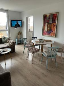 uma sala de estar com um sofá, uma mesa e cadeiras em Apartament nad Wdą em Swiecie