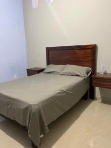 a bed in a room with two nightstands next to a bed sidx sidx at Casa de la esquina in Santa María del Oro