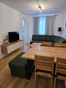 sala de estar con sofá, mesa y sillas en Apartman Novak en Jahorina