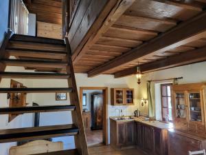 a kitchen with wooden ceilings and a spiral staircase at Apartmány Červený Dvůr in Chvalšiny