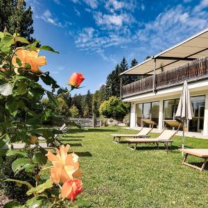 een tuin met banken, een paraplu en een bloem bij Berghotel zum Zirm in Collalbo