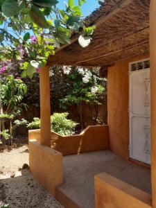 - une entrée pour une maison avec une porte blanche dans l'établissement Campement Baobab, à Poponguine