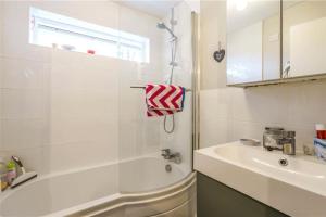 a bathroom with a tub and a sink and a shower at Bright flat in the heart of Chichester in Chichester