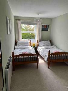 two beds in a bedroom with a window at Bright flat in the heart of Chichester in Chichester