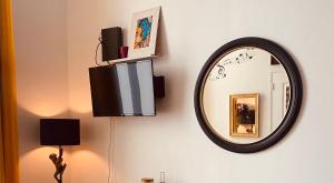 einem Spiegel an einer Wand mit einer Lampe und einem Licht in der Unterkunft Music Box from 10 mn Paris centre in Saint-Ouen
