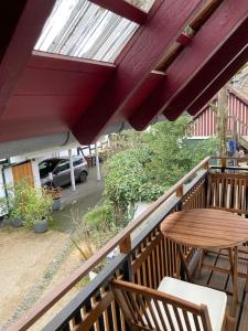 einen Balkon mit einem Holztisch, einem Tisch und Stühlen in der Unterkunft TinyHome_Haus_Helene in Bad Honnef am Rhein