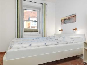 białe łóżko w pokoju z oknem w obiekcie Godewind w mieście Wyspa Poel