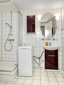 W białej łazience znajduje się umywalka i lustro. w obiekcie Godewind w mieście Wyspa Poel