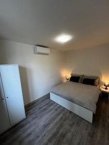 een slaapkamer met een bed en een dressoir met 2 lampen bij The Houses - Chata u sjezdovky 2 in Velké Meziříčí