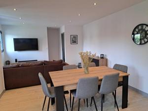 a living room with a wooden table and chairs at Pacific Green in Chalifert