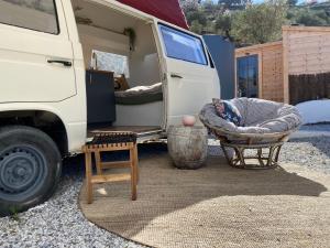 Una furgoneta blanca con una cama y una cama de perro delante en Romantic accommodation - Hottub & Sauna, en Almogía