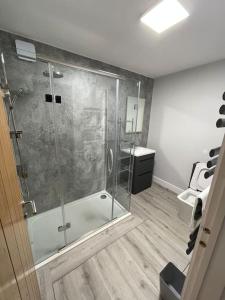 a bathroom with a shower with a glass door at Dog friendly, Roof top hot tub, Panoramic views. in Torquay