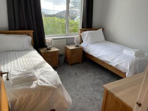 a room with two beds and a window at Dog friendly, Roof top hot tub, Panoramic views. in Torquay